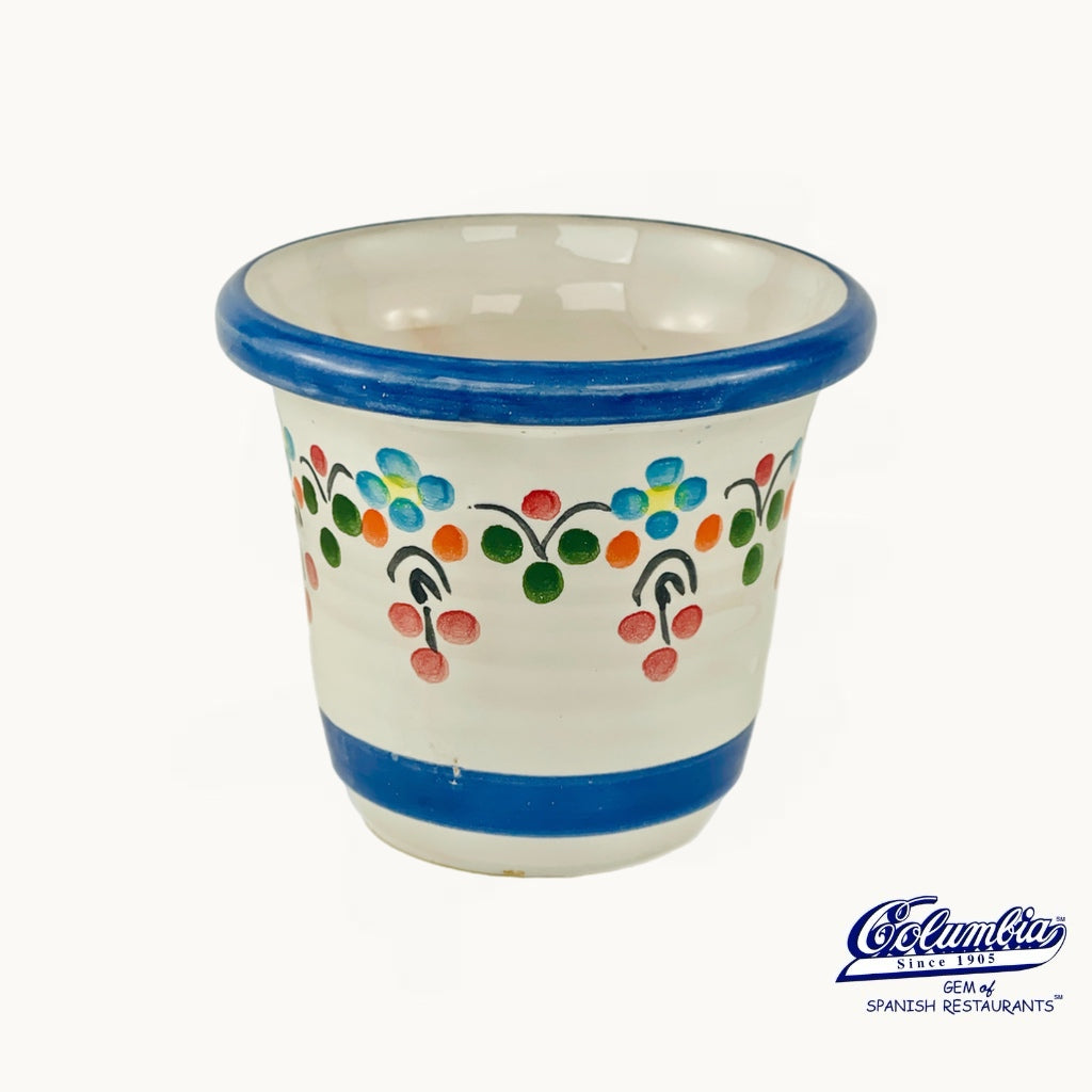 Ceramic cup with colorful patterns on a white background, featuring the Columba logo.