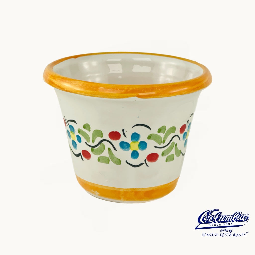 Ceramic cup with floral design and orange rim on a white background, featuring the Columba brand logo.