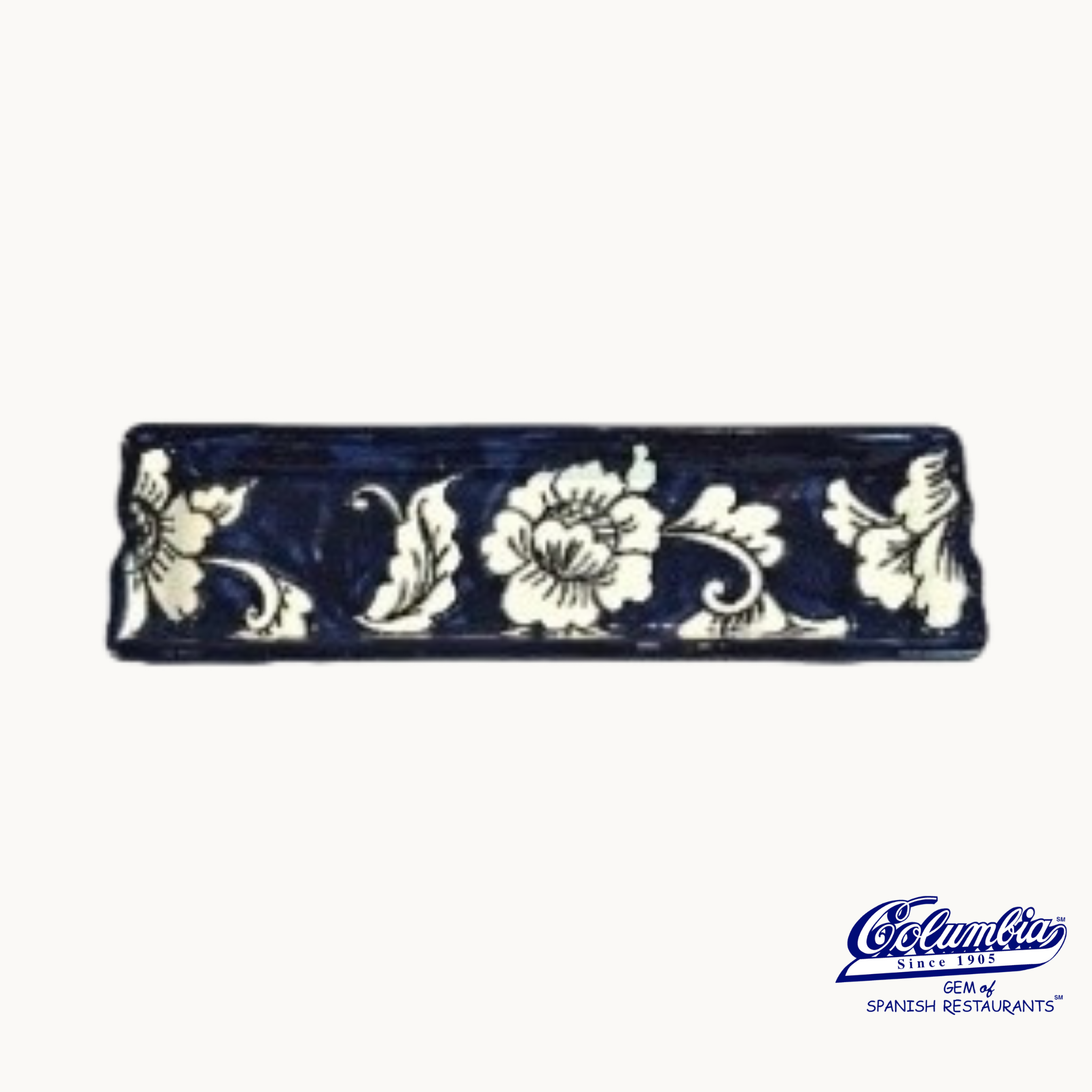 Decorative blue and white ceramic tile with floral patterns on a white background.