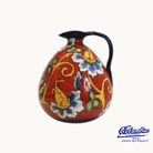 Colorful ceramic pitcher with floral patterns on a white background