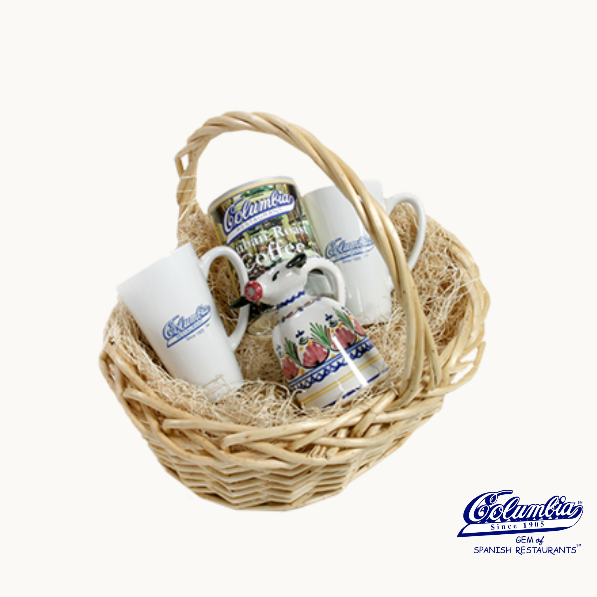Wicker basket with ceramic mugs and bottle on a white background