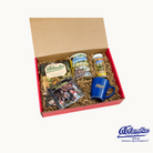 A gift box containing a can of Columbia's private roast Cuban coffee, a Columbia Restaurant Spanish Cookbook, a CD titled 'A Night at the Columbia' featuring Spanish music, a jar of Columbia signature seasoning, and a Columbia logo latte mug.