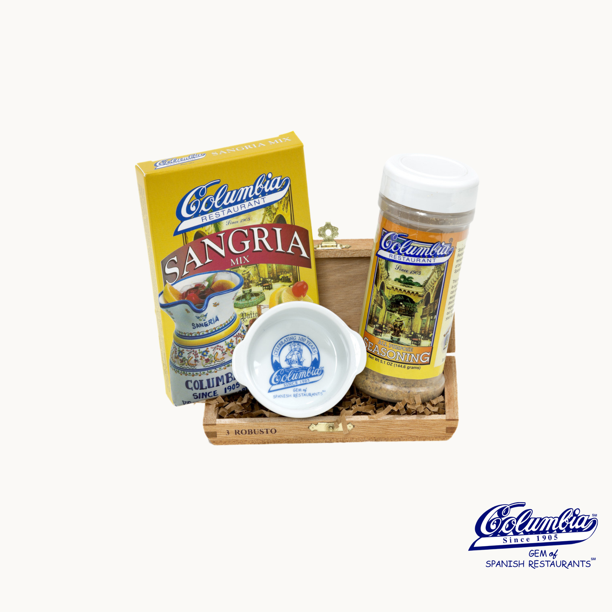 Columbia Spain food products including a box of sangria mix, a bottle of seasoning, and a small bowl on a white background.