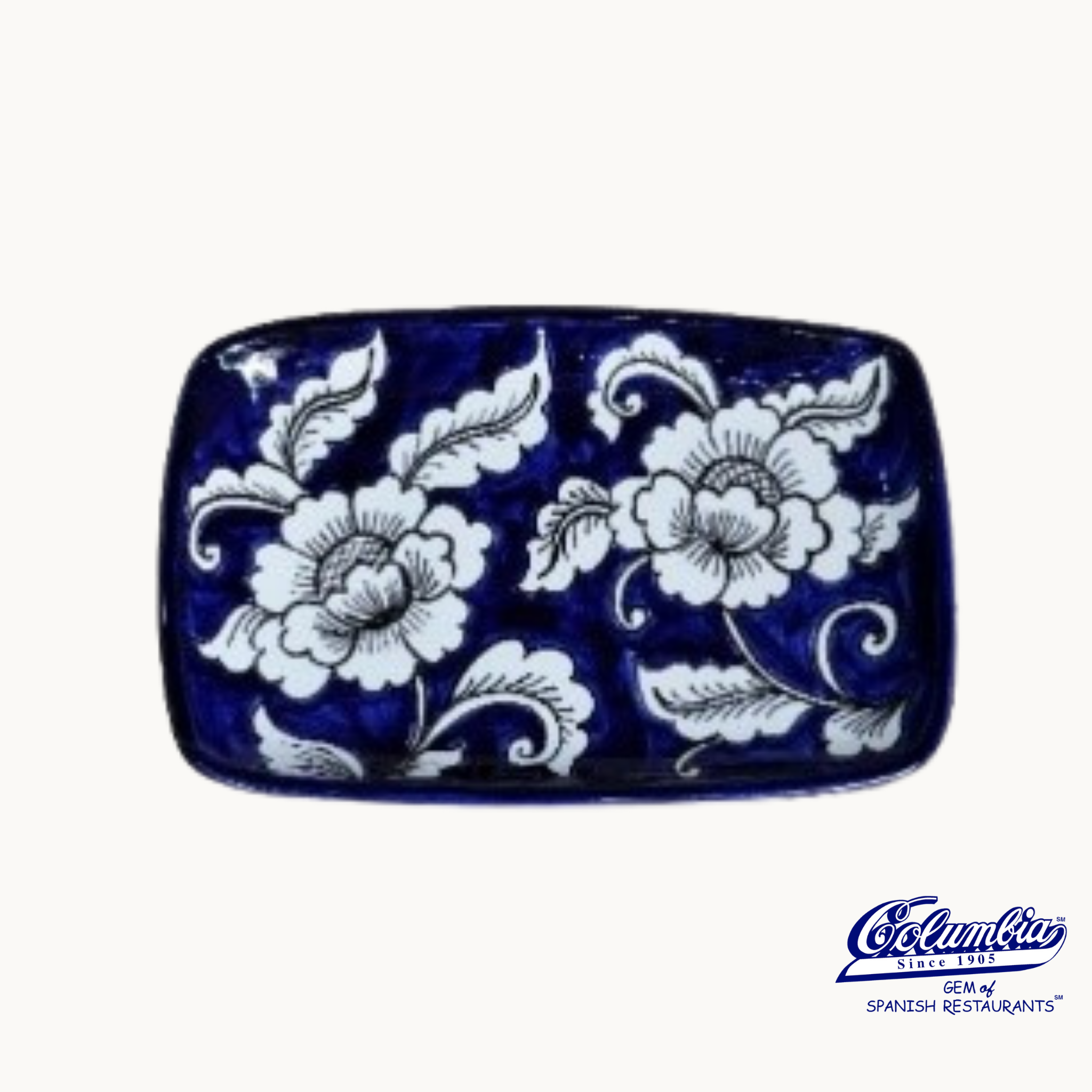 Blue ceramic plate with white floral patterns on a white background