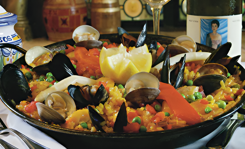 Seafood paella in a pan with mussels, clams, and vegetables on a table.