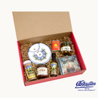 Gift box with Spanish food products including jars and a small plate.