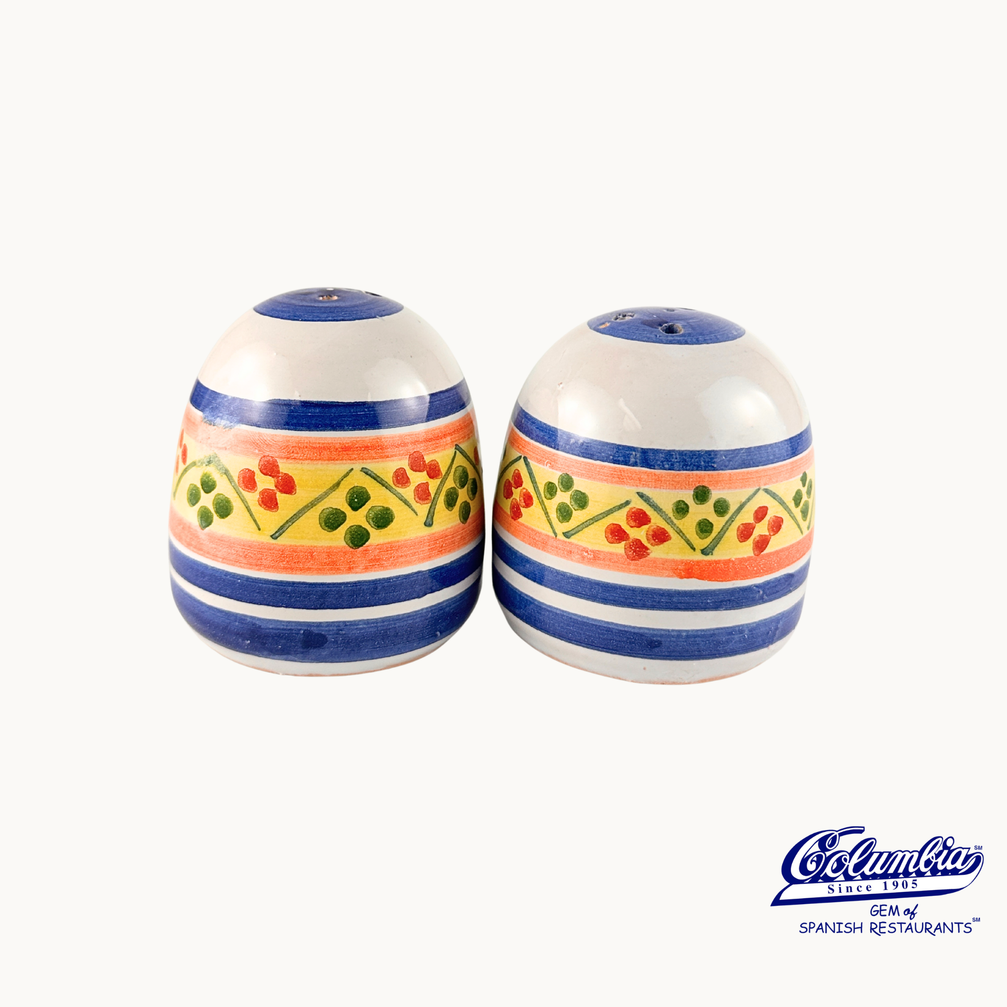 Pair of ceramic salt and pepper shakers with colorful stripes and patterns on a white background, featuring the Columba brand.