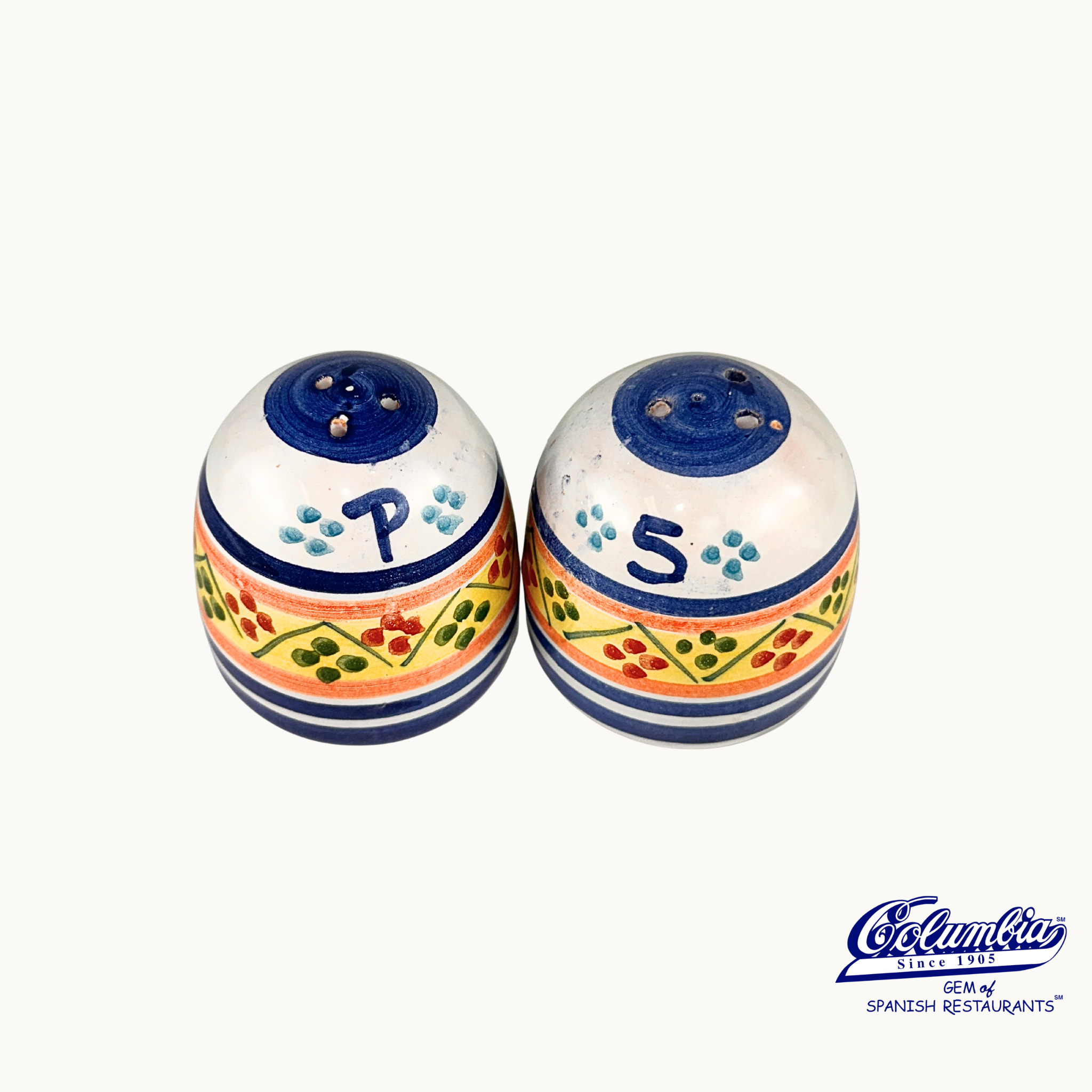 Colorful ceramic salt and pepper shakers with 'P' and 'S' labels on a white background, featuring the Columba logo.
