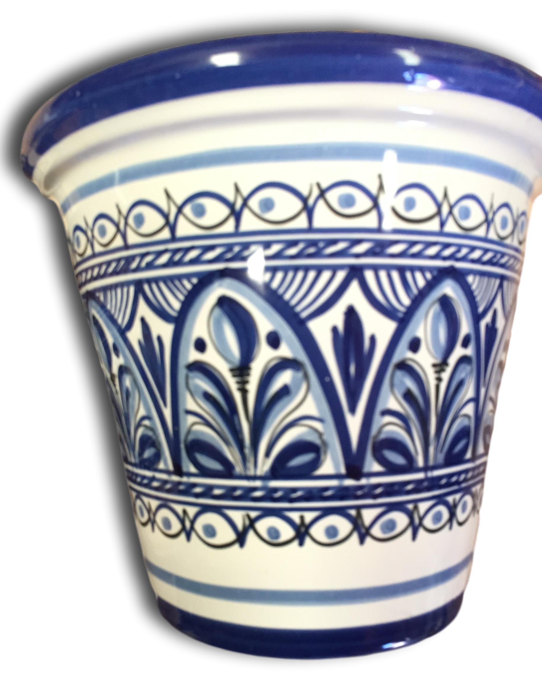 A small, hand-painted flower pot with blue and white floral patterns.