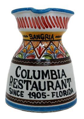 A ceramic pitcher with hand-painted patterns, predominantly white with a colorful geometric design, and text that reads 'COLUMBIA RESTAURANT SINCE 1905 - FLORIDA'.